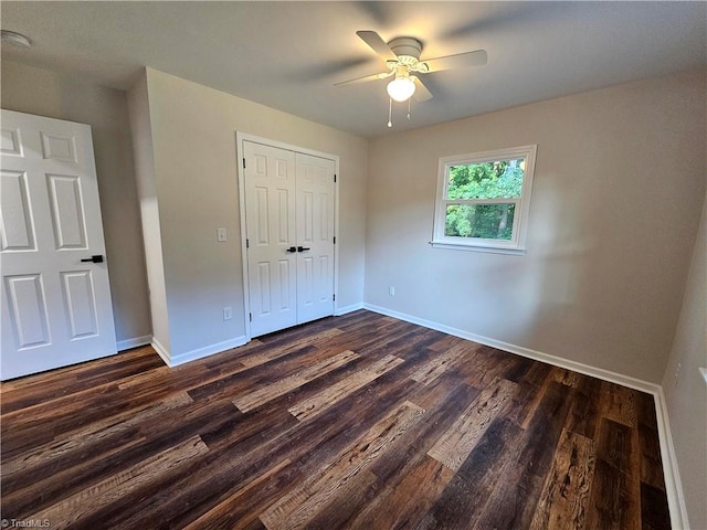 unfurnished bedroom featuring dark hardwood / wood-style floors, ceiling fan, and a closet