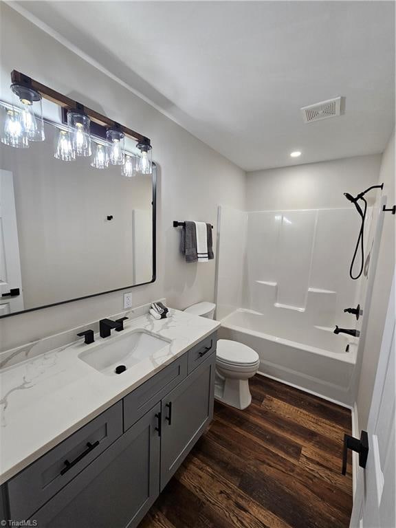 full bathroom with bathing tub / shower combination, vanity, toilet, and wood-type flooring