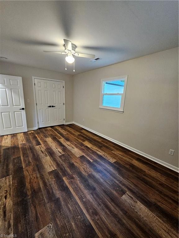 unfurnished bedroom with ceiling fan and dark hardwood / wood-style floors