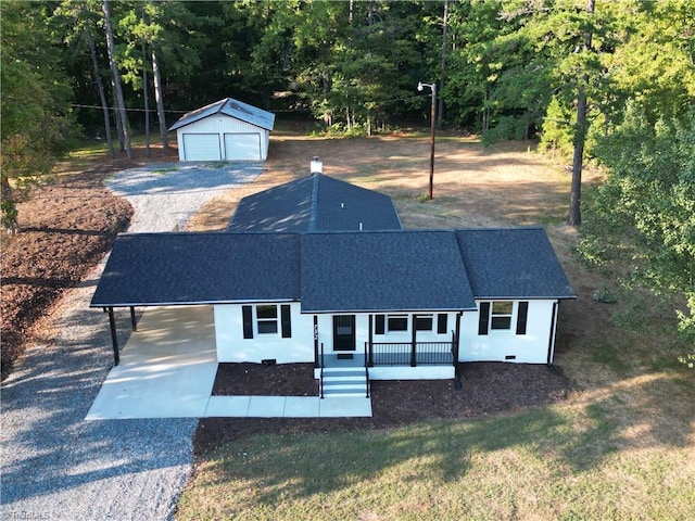 view of front facade featuring an outbuilding, a porch, a garage, and a front lawn