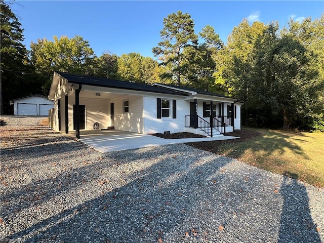 view of front of property with an outdoor structure, a garage, a front lawn, and a carport