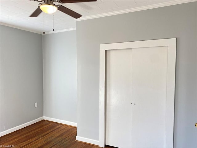 unfurnished bedroom with wood finished floors, a ceiling fan, baseboards, a closet, and crown molding