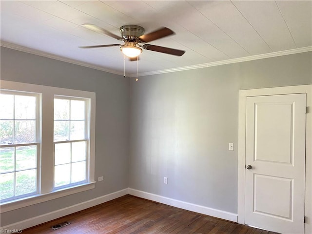 unfurnished room featuring baseboards, visible vents, dark wood-style flooring, and ornamental molding