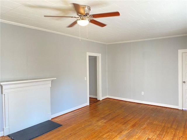 empty room featuring ornamental molding, wood-type flooring, ceiling fan, and baseboards