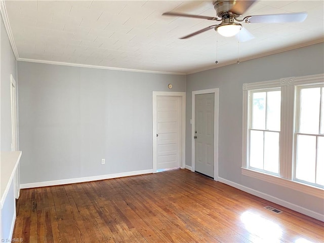 unfurnished room featuring a ceiling fan, wood-type flooring, crown molding, and baseboards