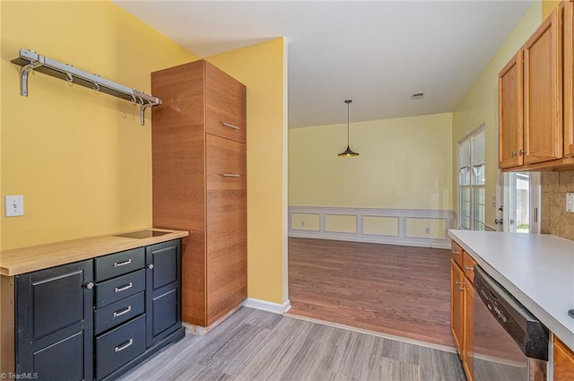 interior space with visible vents, light countertops, light wood-type flooring, brown cabinetry, and stainless steel dishwasher