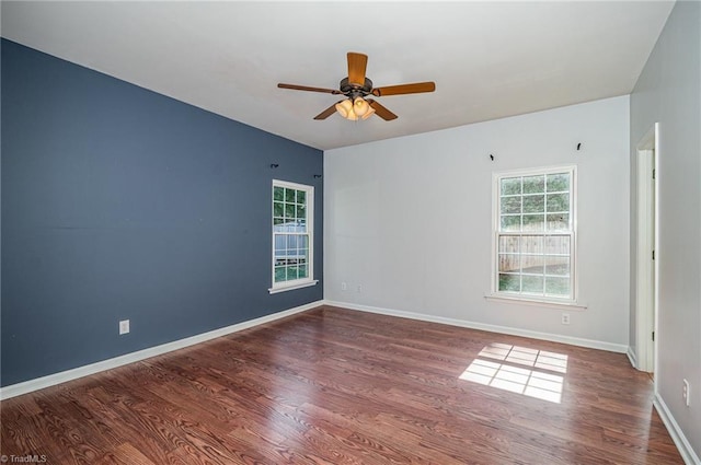 spare room with a ceiling fan, wood finished floors, and baseboards