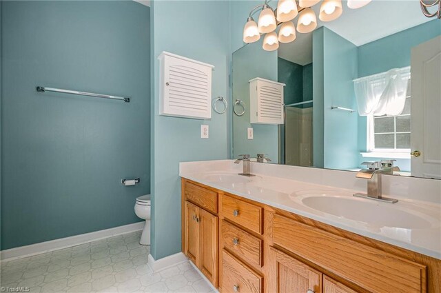 bathroom featuring walk in shower, baseboards, toilet, double vanity, and a sink