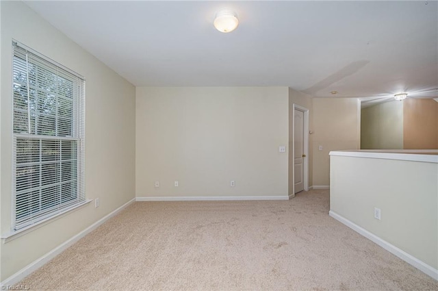 empty room with baseboards and carpet