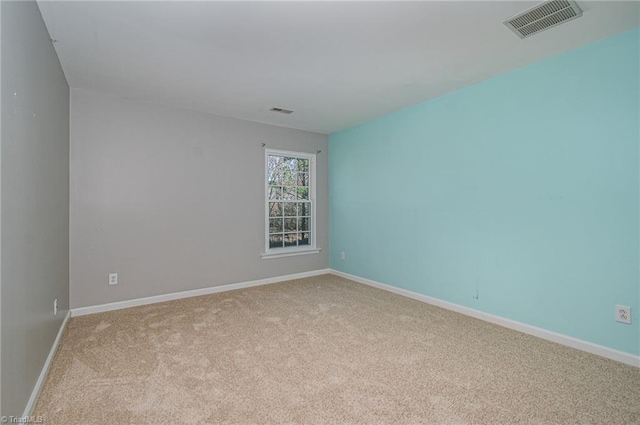 carpeted empty room with visible vents and baseboards