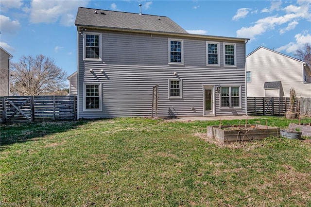 rear view of property featuring a garden, a yard, and fence private yard