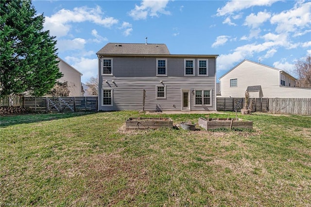 rear view of house featuring a garden, a yard, and a fenced backyard