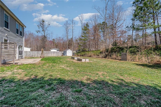 view of yard featuring a patio area, a shed, an outdoor structure, and fence