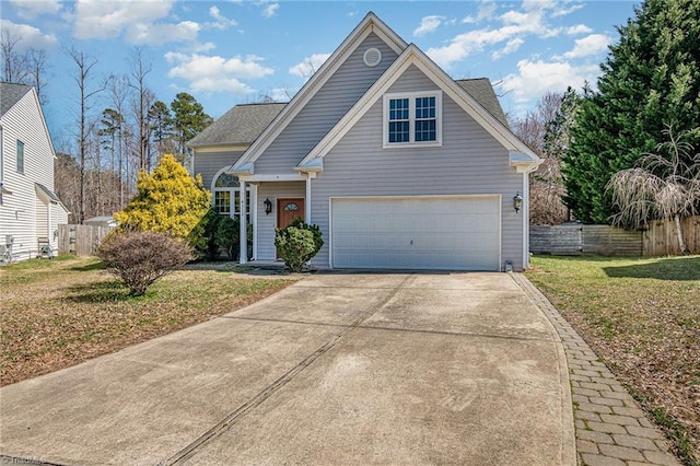 traditional-style house with a garage, concrete driveway, a front lawn, and fence