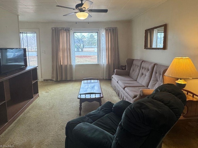 living room with plenty of natural light, visible vents, a ceiling fan, and light colored carpet