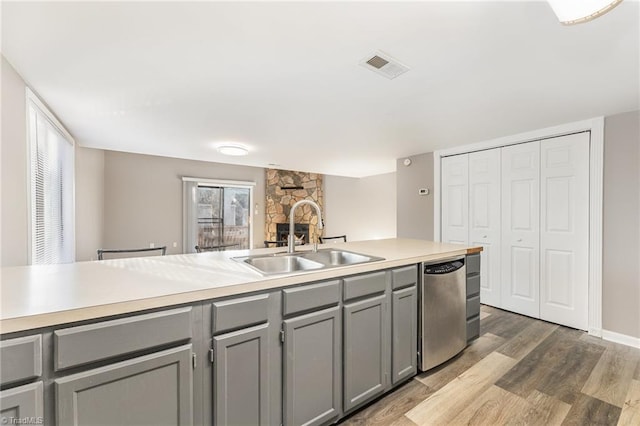 kitchen with a sink, visible vents, light countertops, stainless steel dishwasher, and gray cabinets