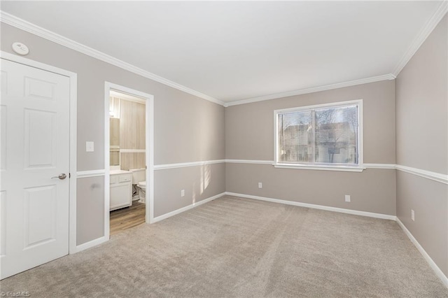 empty room with light carpet, baseboards, and crown molding