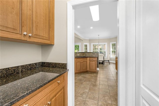 4455 Greystone Place Ct, Winston-Salem, NC 27106 - kitchen featuring crown molding, brown cabinets, recessed lighting, dark stone counters, and decorative light fixtures