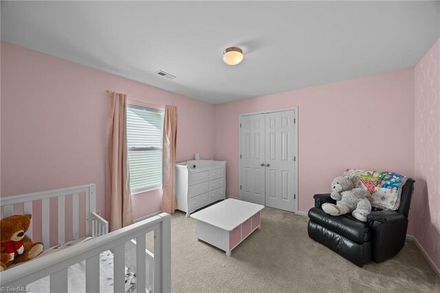 bedroom with light carpet and a closet