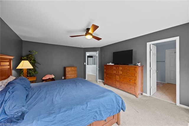 bedroom with light carpet, baseboards, and a ceiling fan