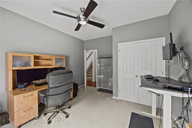office with light colored carpet, a ceiling fan, and baseboards