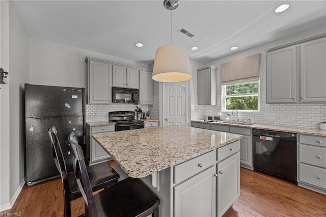 kitchen with black appliances, gray cabinetry, a sink, and recessed lighting