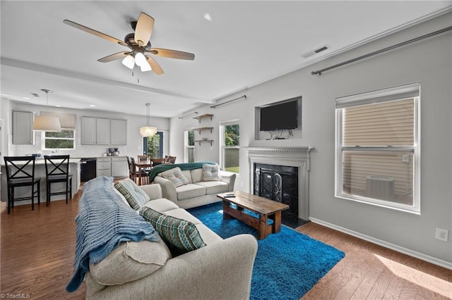 living area featuring dark wood-style floors, a fireplace with raised hearth, baseboards, ceiling fan, and recessed lighting