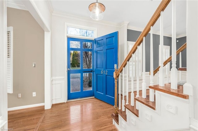 entrance foyer with ornamental molding and light hardwood / wood-style flooring