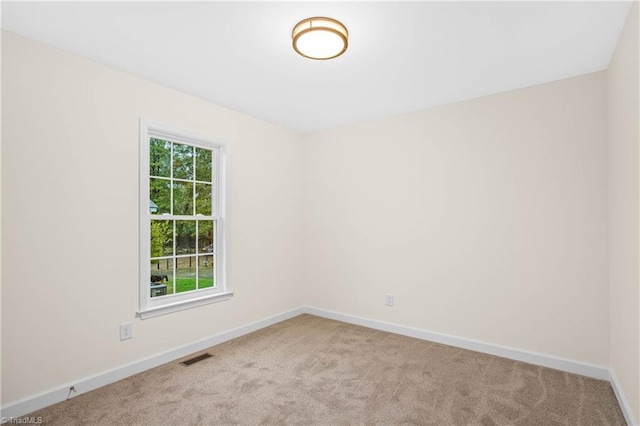 unfurnished room with visible vents, baseboards, and carpet