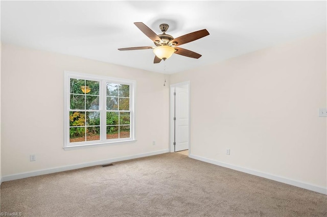 carpeted empty room with visible vents, ceiling fan, and baseboards