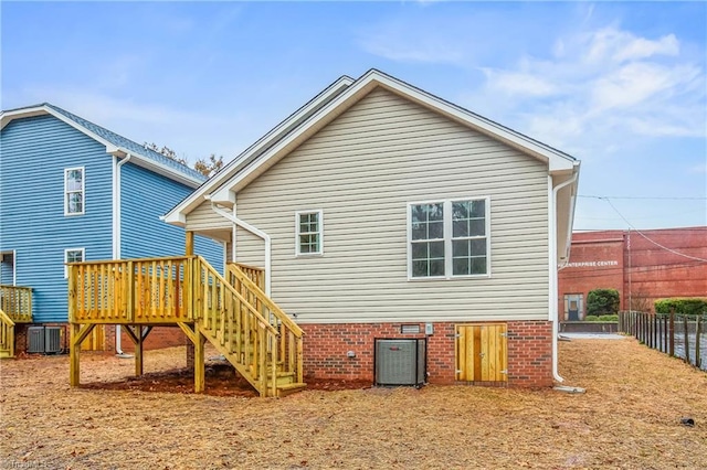 back of property with central air condition unit, stairway, a deck, and fence