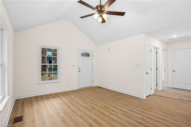 interior space with visible vents, light wood-style flooring, baseboards, ceiling fan, and vaulted ceiling