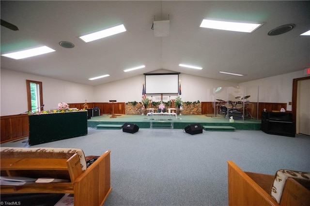 misc room featuring carpet floors, vaulted ceiling, and wooden walls