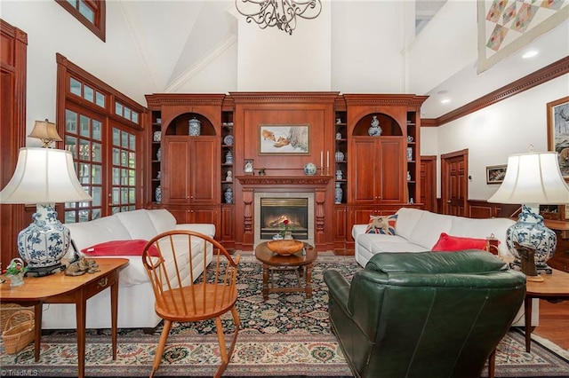 4432 Bent Tree Farm Rd, Winston-Salem, NC 27104 - living area featuring high vaulted ceiling, a chandelier, ornamental molding, a glass covered fireplace, and a wainscoted wall