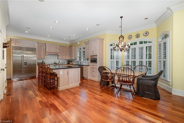 4432 Bent Tree Farm Rd, Winston-Salem, NC 27104 - kitchen with built in appliances, a chandelier, a breakfast bar, wood finished floors, and dark countertops