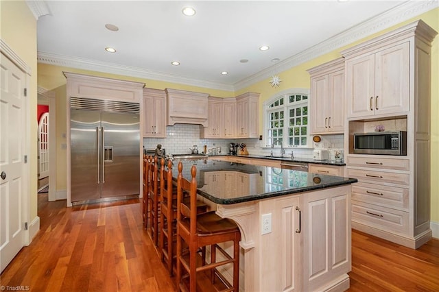 4432 Bent Tree Farm Rd, Winston-Salem, NC 27104 - kitchen featuring appliances with stainless steel finishes, light wood finished floors, a kitchen island, decorative backsplash, and recessed lighting