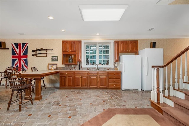 4432 Bent Tree Farm Rd, Winston-Salem, NC 27104 - kitchen with freestanding refrigerator, brown cabinetry, recessed lighting, decorative backsplash, and light stone finish flooring