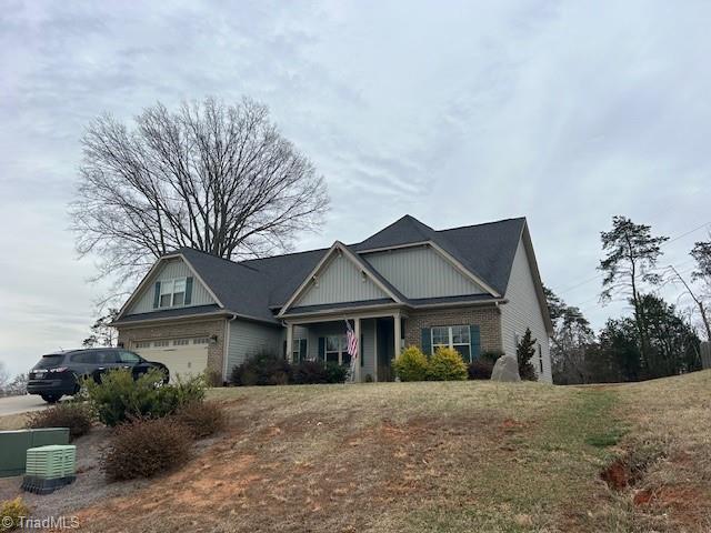 craftsman house with a garage and brick siding