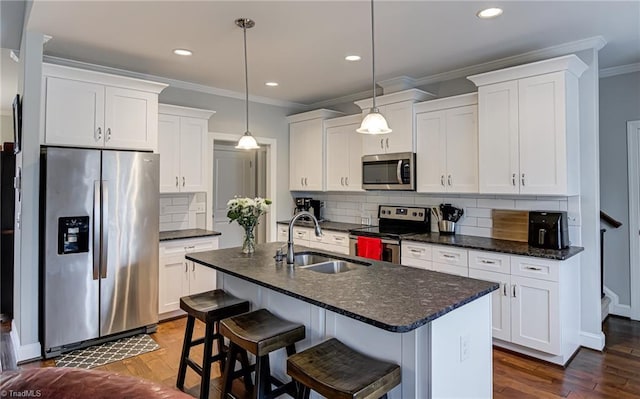 kitchen featuring dark wood finished floors, appliances with stainless steel finishes, a sink, and white cabinetry