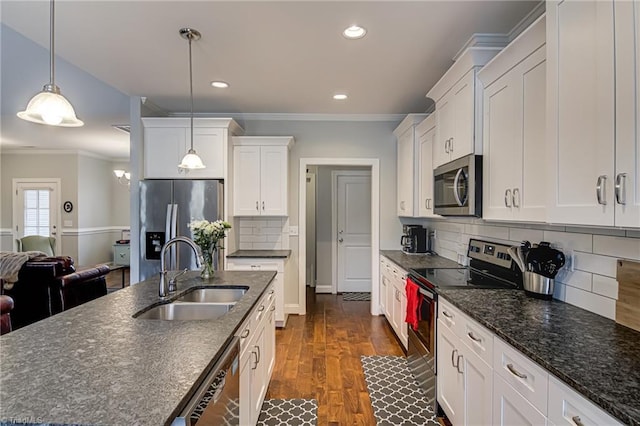 kitchen with dark wood-style floors, stainless steel appliances, a sink, and crown molding