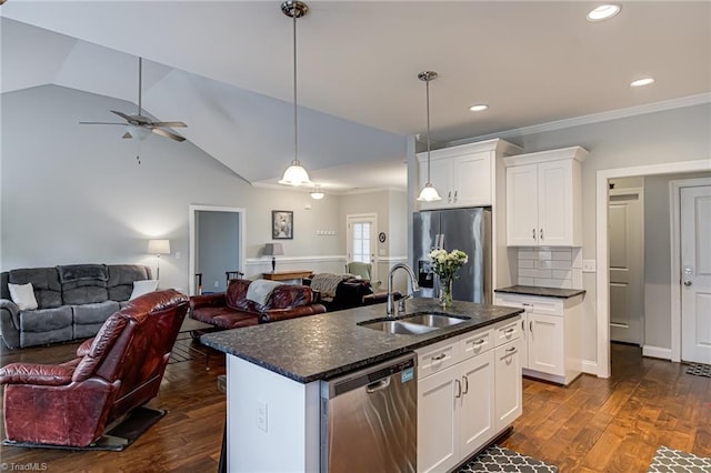 kitchen with dark wood-style floors, appliances with stainless steel finishes, open floor plan, white cabinets, and a sink