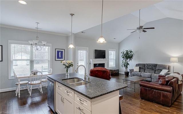 kitchen with open floor plan, stainless steel dishwasher, a fireplace, and a sink