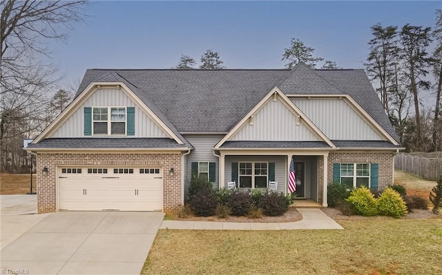 craftsman inspired home with driveway, brick siding, an attached garage, fence, and a front yard