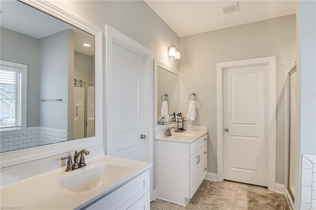 bathroom featuring two vanities, visible vents, and a sink