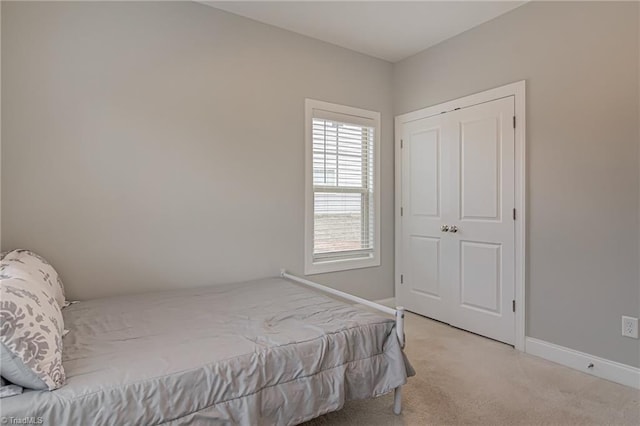 bedroom with light carpet and baseboards