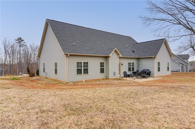 rear view of house featuring a yard, roof with shingles, and a patio