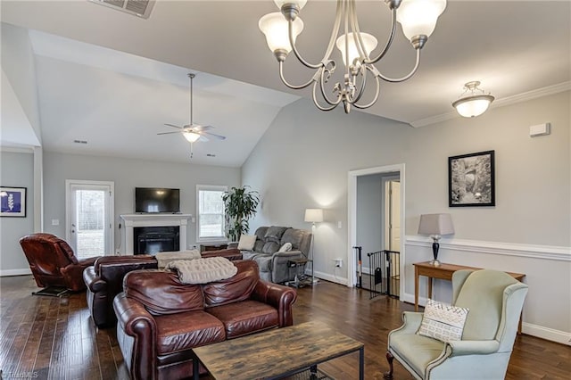 living room with baseboards, dark wood finished floors, a glass covered fireplace, vaulted ceiling, and ceiling fan with notable chandelier