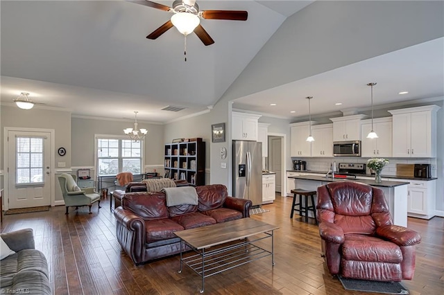 living area featuring dark wood-style floors, visible vents, ornamental molding, and ceiling fan with notable chandelier