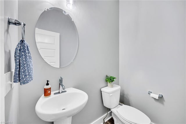 5166 Whaitley Ln, Greensboro, NC 27407 - half bath with a sink, toilet, and baseboards