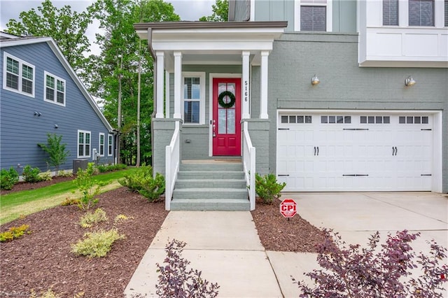 5166 Whaitley Ln, Greensboro, NC 27407 - view of exterior entry with a garage, brick siding, and concrete driveway